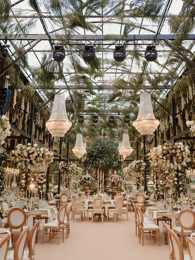 Wedding reception in a glasshouse with chandeliers